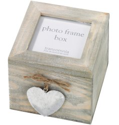 A decorative wooden storage box with photo frame lid and metal heart adornment. 