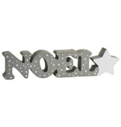 Wooden block with "Noel" text featuring a grey background with star print pattern.