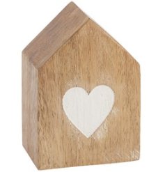 A decorative solid wooden block in the shape of a house with painted heart detail.