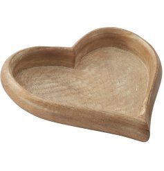 A large natural wooden decorative tray in a heart shape.