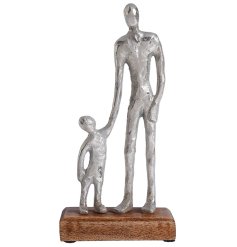 A silver aluminium metal father and child decorative ornament on a contrasting wooden base. 