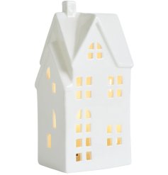 A pretty ceramic house lantern with led light and cut out detailing.