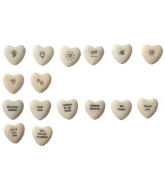 An assortment of little heart shaped pebbles each with a sentimental message or sweet illustration printed on it.