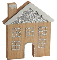 A festive wooden house decoration featuring a glitter roof, windows and snow details and cut out door design. 