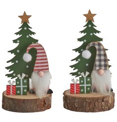 A cute decoration with Santa stood in front of a tree with presents on a wooden base. 