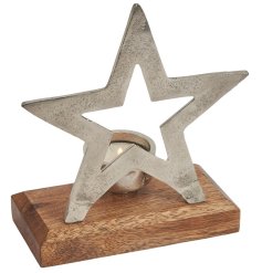 A stunning silver metal star with cut out detailing and tea light holder on a wooden base. 