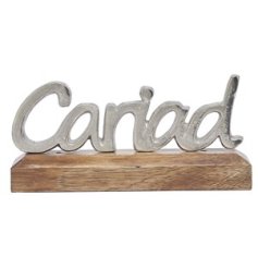 A beautiful decorative item with "love" text in Welsh presented on a wooden base. 