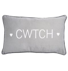 A rectangular grey cushion cover finished with a piped edge, white heart details and Welsh "hug" text. 