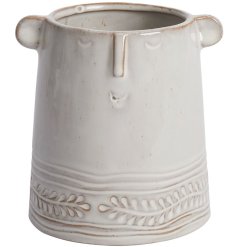 An on trend face vase with beautifully carved details and a rustic neutral glaze.