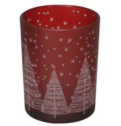 A festive tea light holder with a deep red background and silver tree and snowflake design. 