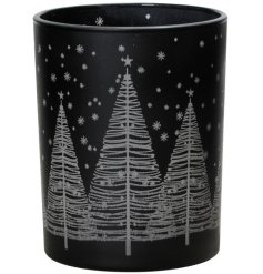 A festive tea light holder with silver tree and snowflake detail on a stylish black background. 