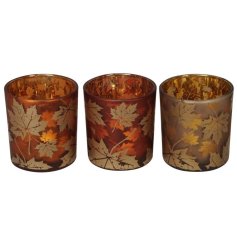 3 Assorted tea light holders, each with a tonal copper background and leaf print design. 
