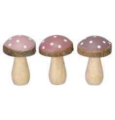 An assortment of 3 wooden mushrooms each with a bark edge detail with pink/purple colour scheme and white spots. 