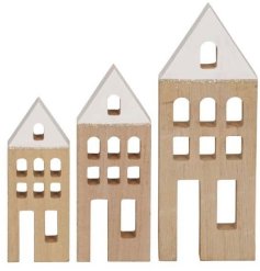 A set of 3 wooden house decorations each with feature white roof, glitter and cut out details.