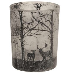 A glass tea light holder with frosted design featuring a woodland scene pattern with deer and stag detail.