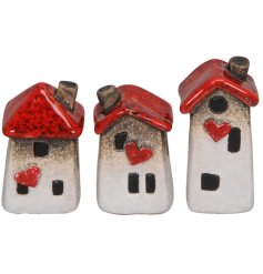 An assortment of 3 stone house decorations, each with a characterful "wonky" design and red heart and roof details. 
