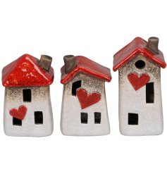An assortment of 3 stone house decorations, each with a characterful "wonky" design and red heart and roof details. 