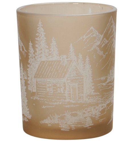 A fawn coloured glass tea light holder with a white snowy mountain range and log cabin design. 