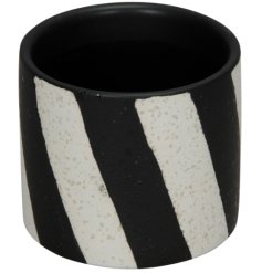 A stone plant pot with a bold monochrome striped design. 