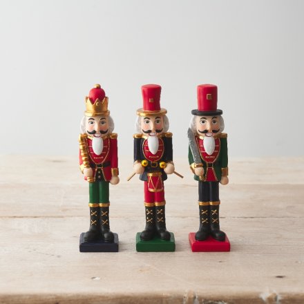 A mix of 3 traditional nutcracker ornaments, each painted in rich green and red colours with gold detailing. 