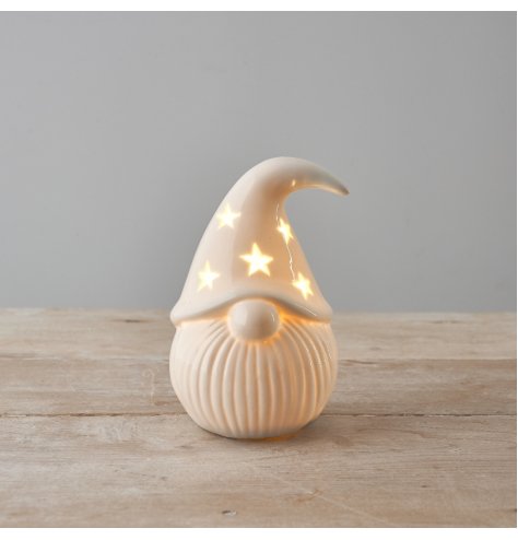 A stylish white ceramic santa ornament with a star design hat and warm glow led lights. 