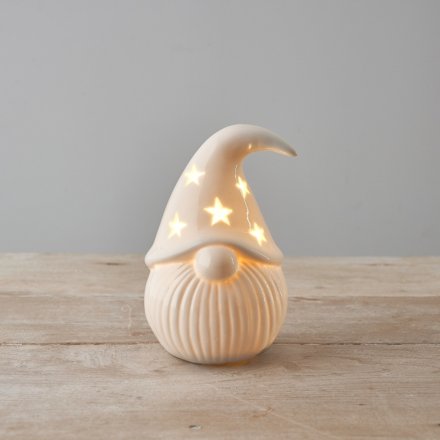 A classic ceramic Santa ornament with star cut out detail and a warm glow LED light. 