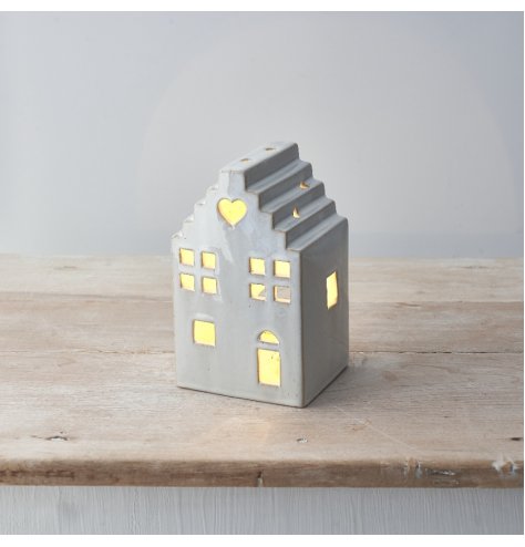 A stylish ceramic house with cut out details and an LED T-Light. 
