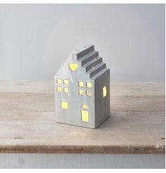 A stylish ceramic house with LED T-Light. A stylish interior accessory with a natural finish. 