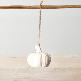 A white ceramic pumpkin decoration with ribbed detailing and a jute string hanger. 