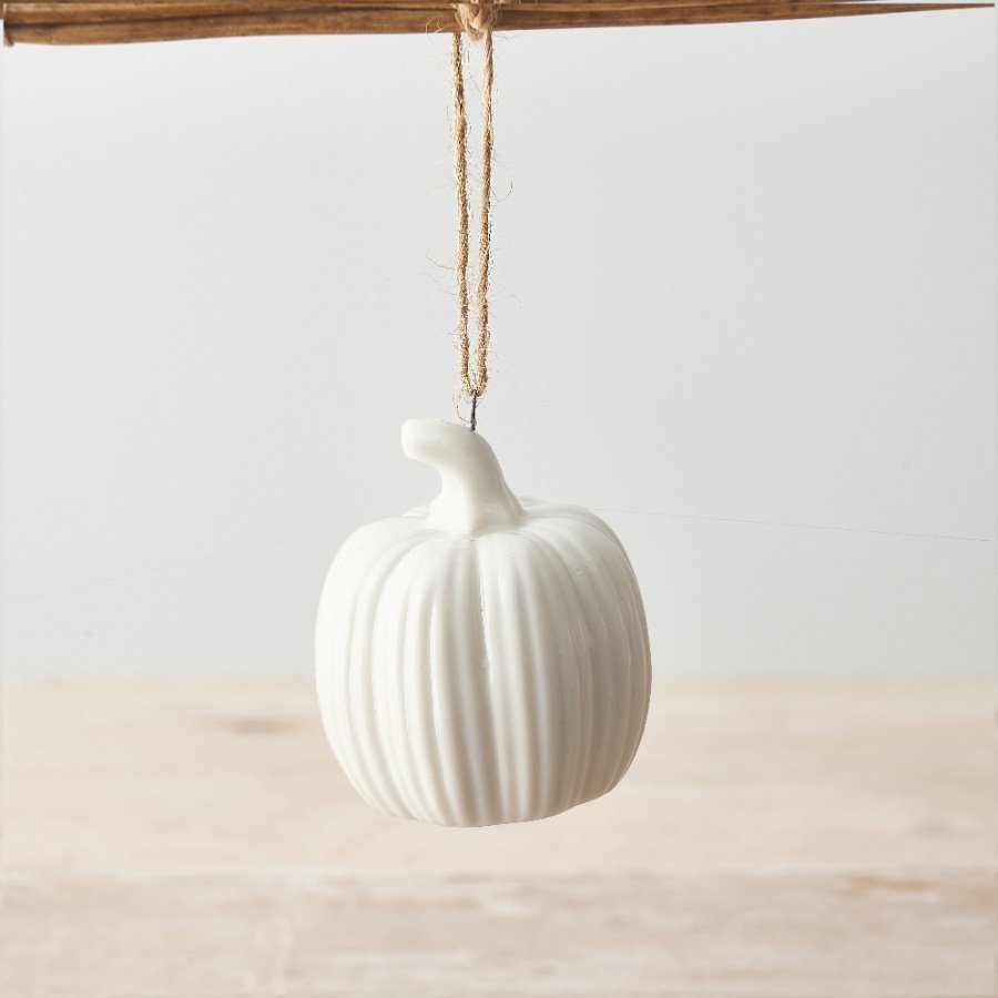 A chic white ceramic pumpkin with ridges and a jute string hanger. 