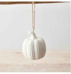 A chic white ceramic pumpkin decoration with a rustic jute string hanger. 