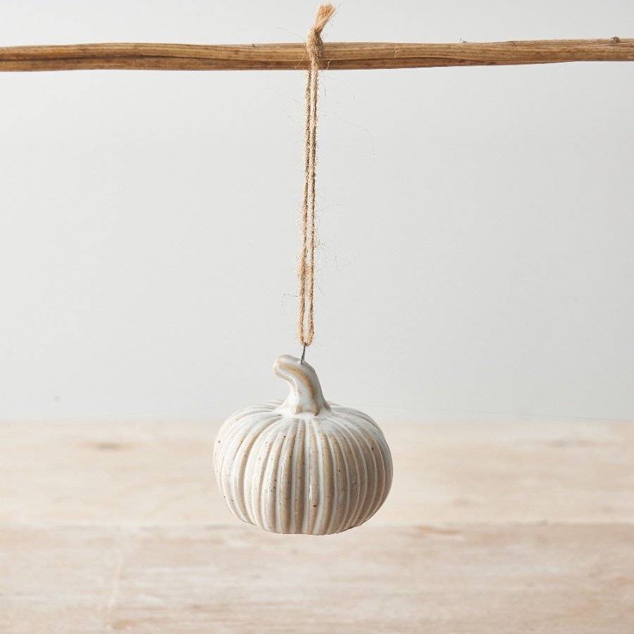 A small ceramic pumpkin decoration with a rustic, natural finish and jute string hanger.