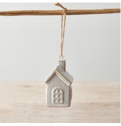 A chic ceramic house shaped decoration with charming cottage style windows and doors. 