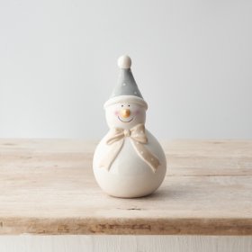 A charming snowman decoration with blush cheeks and a sweet polka dot bow and hat. 