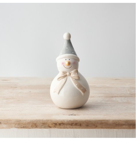 A charming snowman decoration with polkadot bow and hat. A cute accessory for the home this season. 