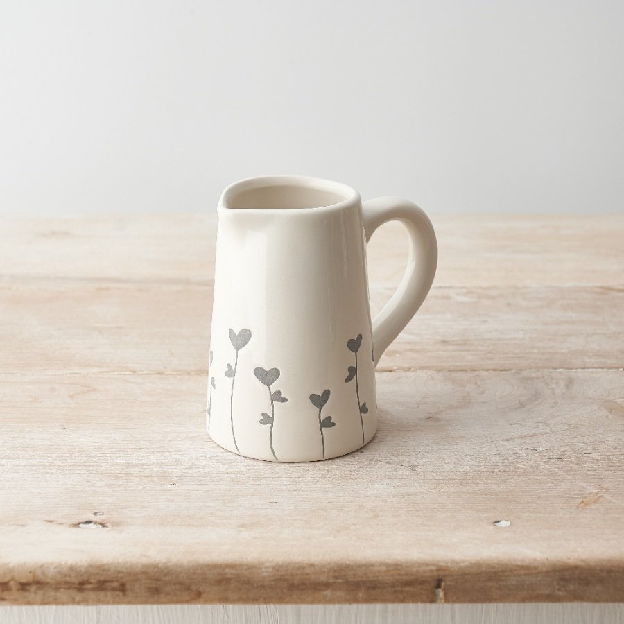 A charming jug with a dainty grey floral design cascading around the sides. 