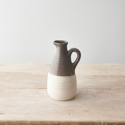 A stylish ceramic jug with a dainty spout and handle. Raw at the base with a warm grey glaze. 