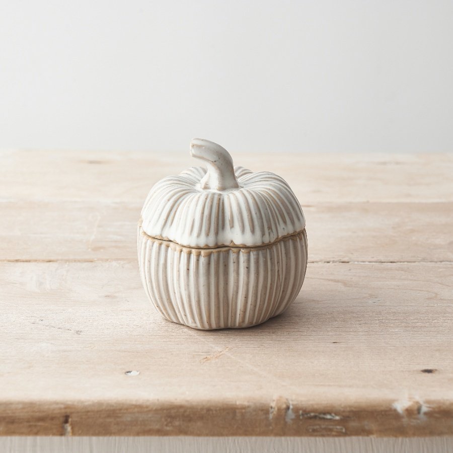 A ceramic pumpkin lidded container in a natural colour scheme with stipe detailing. 