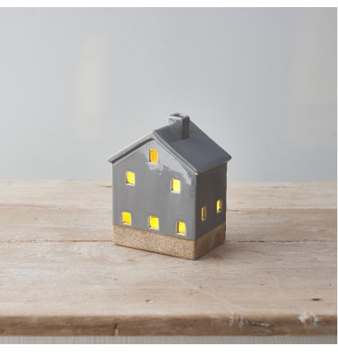 A sweet ceramic light up house with a stylish grey colour scheme, contrasting base design and cut out detailing. 