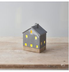 A stylish ceramic house with light up feature, on trend grey design, cut out details with contrasting base. 