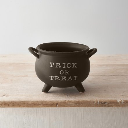 A unique cauldron shaped pot in black with trick or treat slogan.