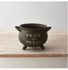 A unique cauldron shaped pot in black with trick or treat slogan.