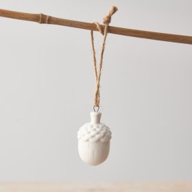 A simple and elegant white acorn decoration with a jute string hanger. 