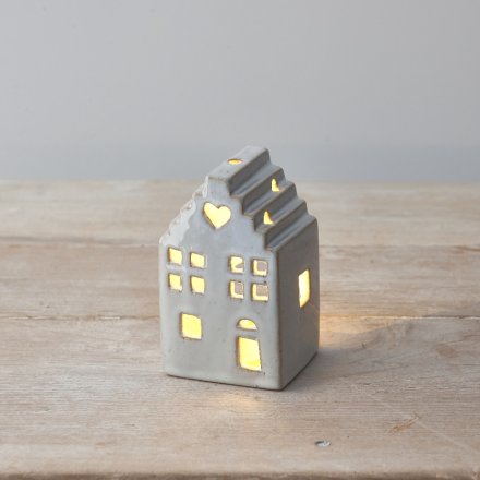 A charming ceramic house ornament with a rustic finish and warm glow t-light candle. 