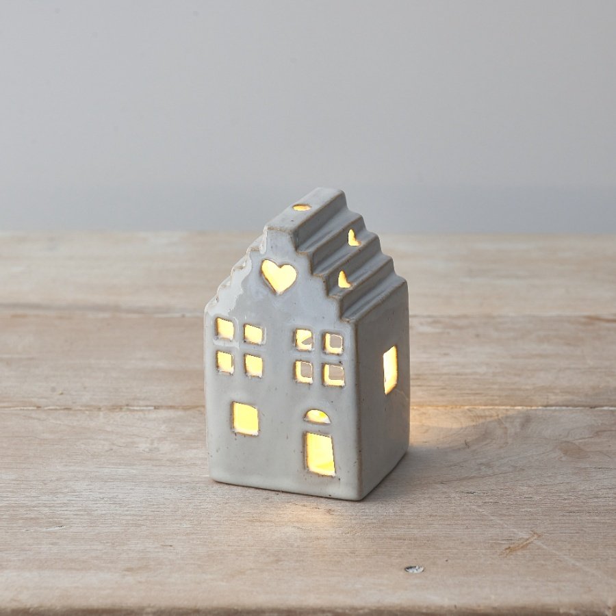 A charming ceramic house with a rough luxe finish and dainty heart detail. Complete with a warm glow LED T-light candle.