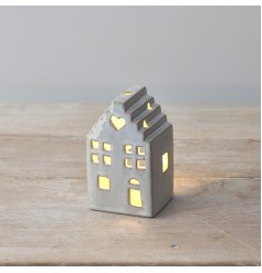 A charming ceramic house ornament with a rustic finish and warm glow t-light candle. 