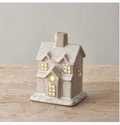 A rustic light up house ornament with a natural glaze and warm glow lights. 