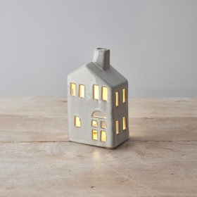 A stylish ceramic house with chimney. A rustic ornament complete with a warm glow led t-light candle. 
