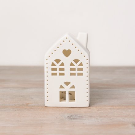 A white ceramic house shaped decoration with light up feature, cut out design and heart detail. 
