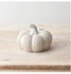 A cute ceramic pumpkin decoration with ribbed design detail.